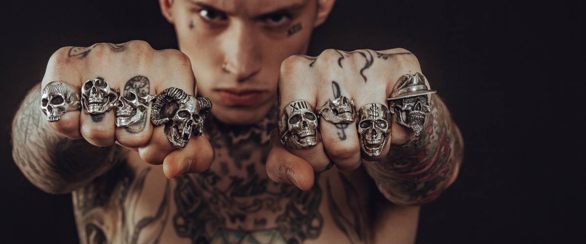 punk with tattoos and skull rings